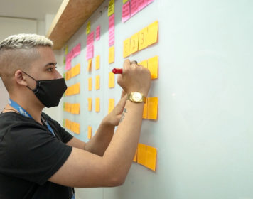 Na imagem, um colaborador da UDS em dinâmica de design sprint pra determinar o mínimo produto viável, o MVP de um desenvolvimento de software.