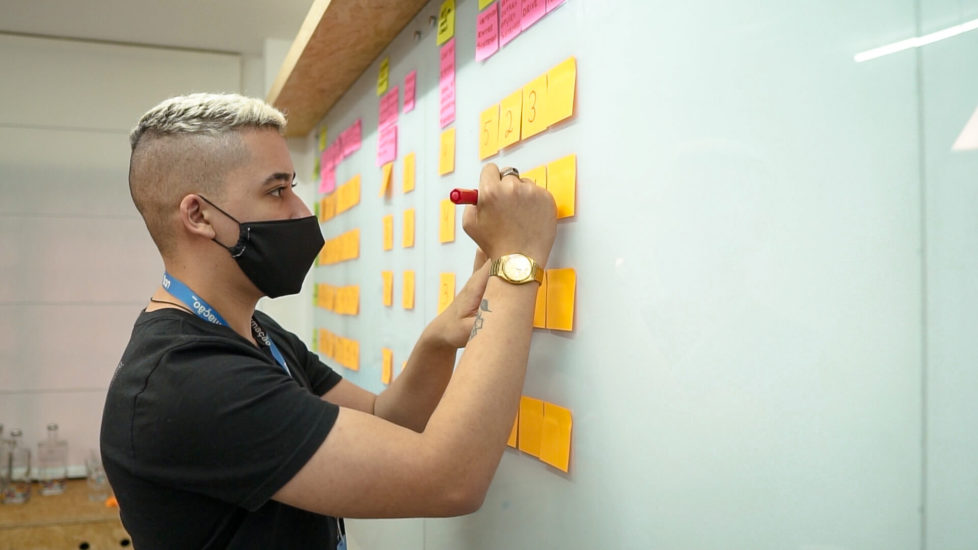 Na imagem, um colaborador da UDS em dinâmica de design sprint pra determinar o mínimo produto viável, o MVP de um desenvolvimento de software.