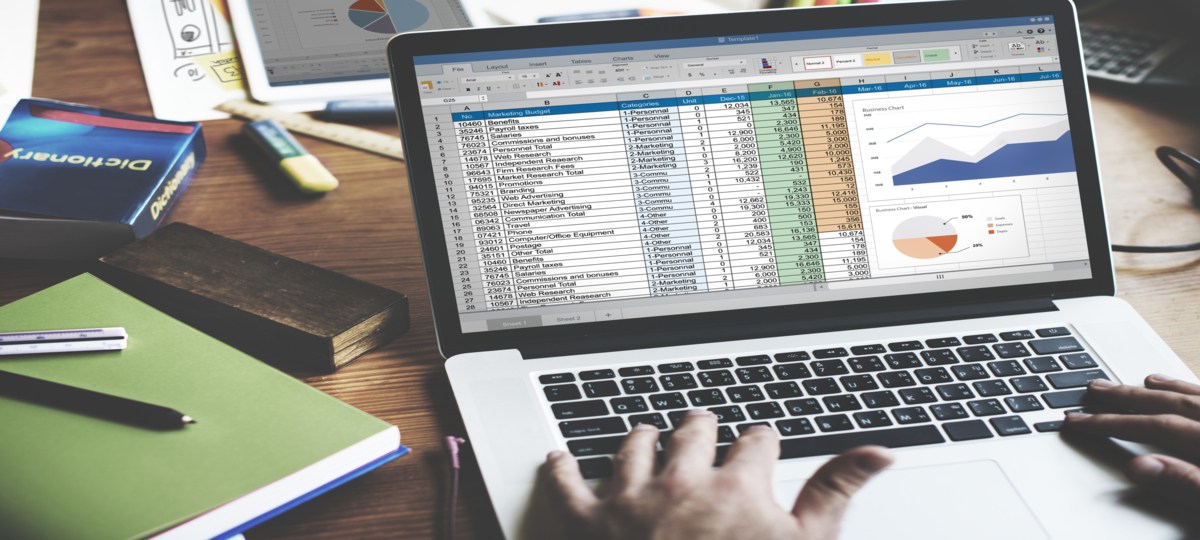 maos humanas digitam em laptop cinza claro com tela focada em planilhas e gráficos de dados, simbolizando uma consultoria de bi