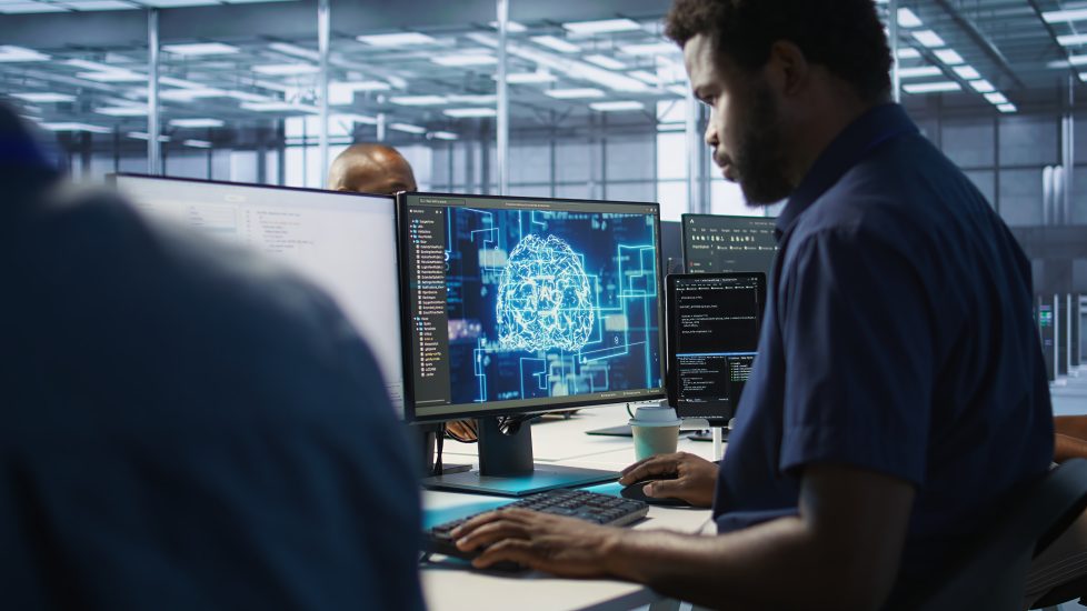 homem trabalhando em frente a computador com data analytics e simbolo de dados em azul brilhante
