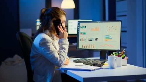 mulher gerente olha para computador com gráficos de dados sinalizando a importânica de uma ingestão de dados que é feita corretamente